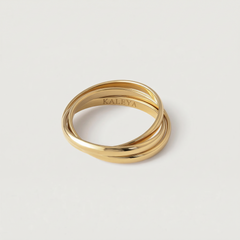 Three gold rings stacked on a light gray background with 'KALEYA' branding.