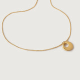 A gold-plated necklace with a simple circular charm and a textured chain.