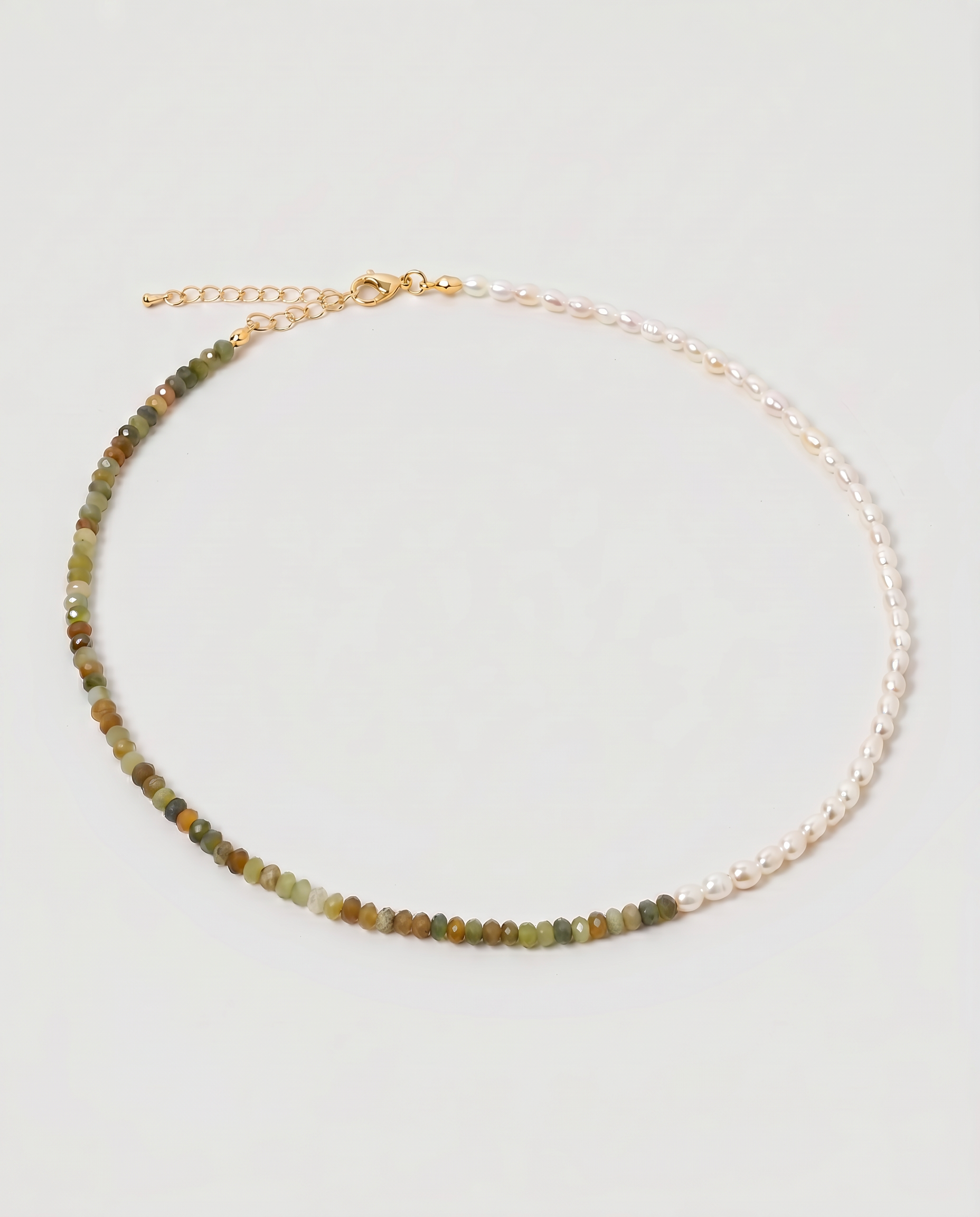 multi gemstone and pearl beaded necklace in gold, with one half strung with imitation pearl rice beads and the other half with faceted mixed quartz beads in green, sage, olive and warm brown tones, joined by a gold accent bead.