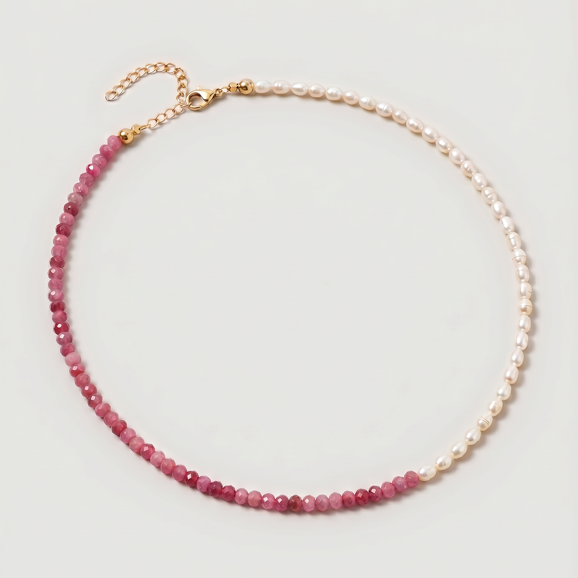  Rose quartz and pearl beaded necklace in gold, with one half strung with imitation pearl rice beads and the other half with faceted rose quartz beads graduating from soft blush to deep pink.