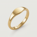 A gold signet ring with a smooth, curved surface on a white background.