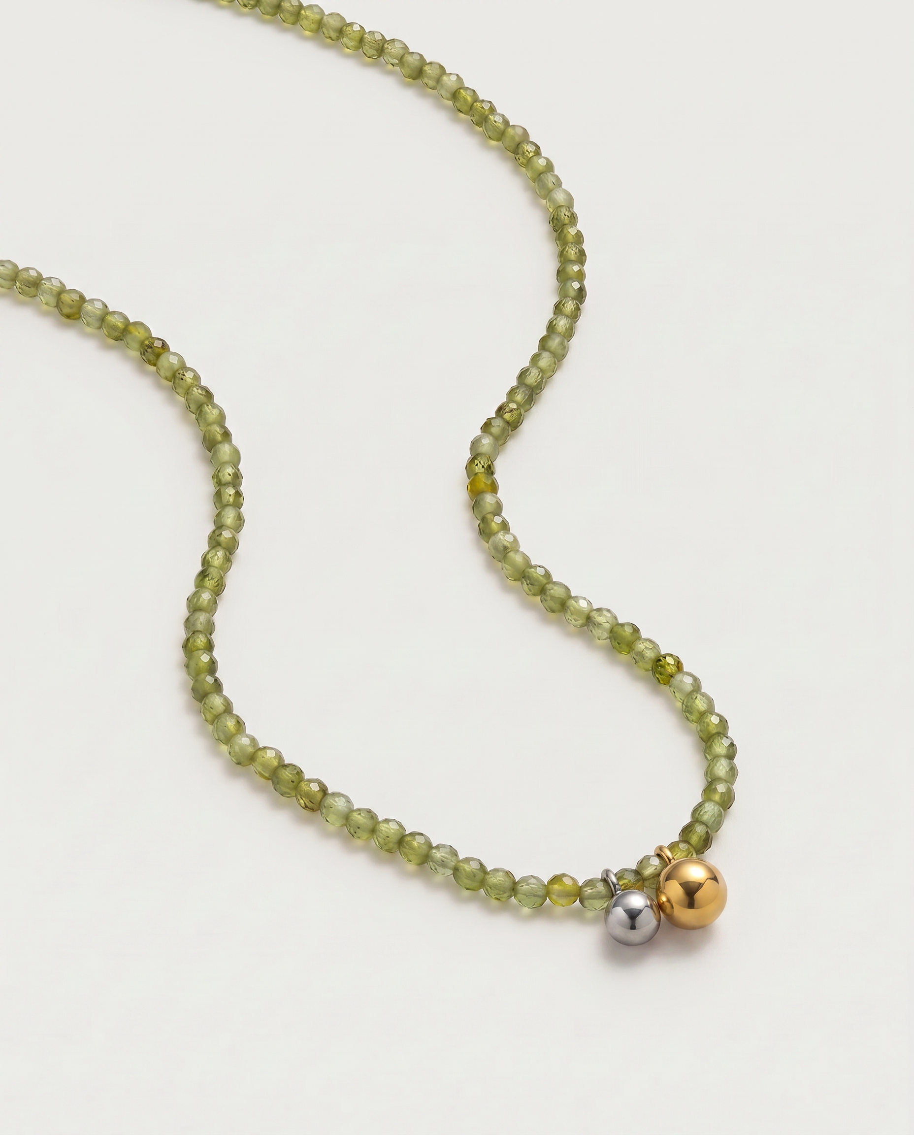 Olive green beaded necklace in gold, with green cubic zirconia beads and a two-tone pendant 
