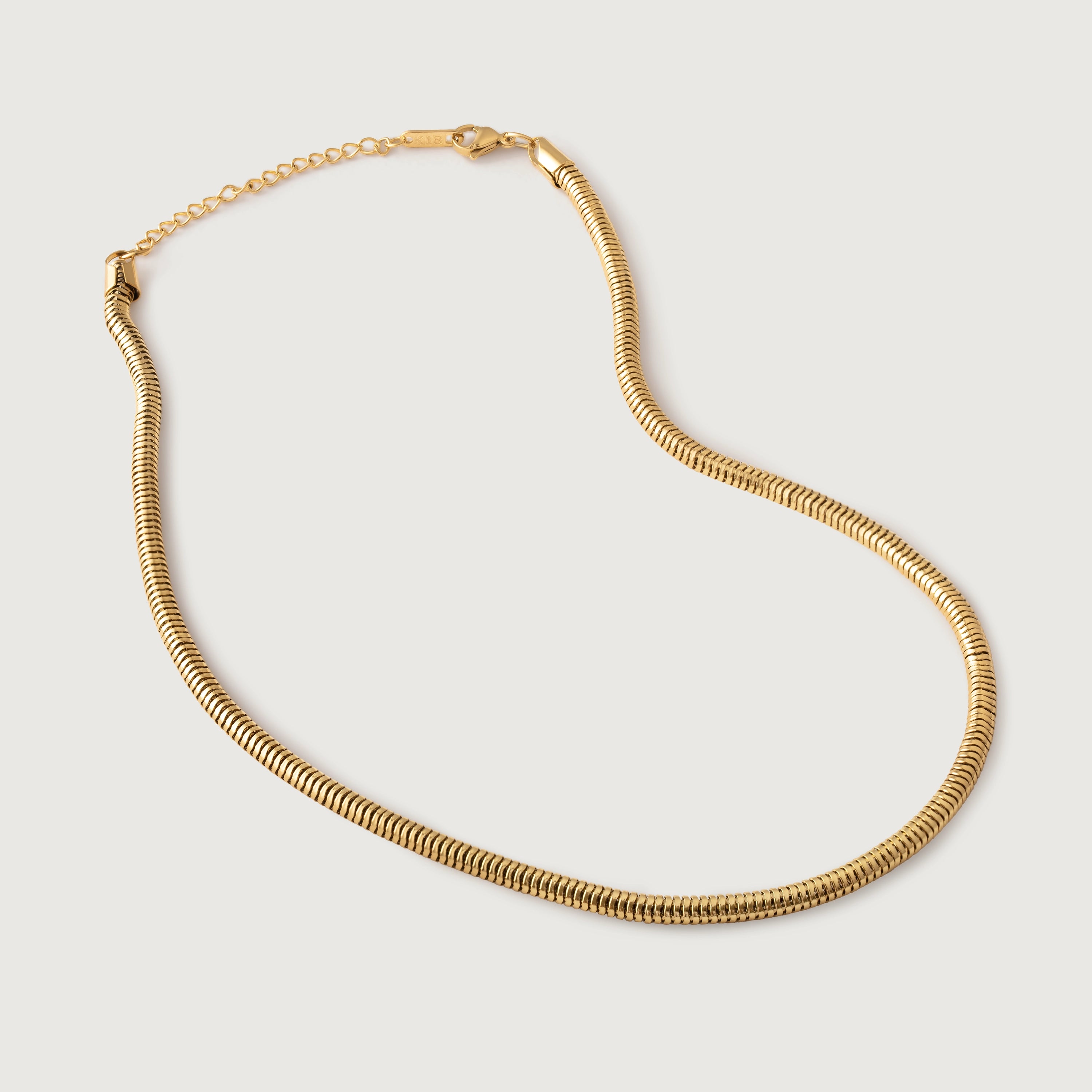 A gold-colored snake chain choker necklace on a white background.
