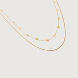 A two-tone necklace with gold links and yellow stones, displayed against a white background