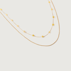 A two-tone necklace with gold links and yellow stones, displayed against a white background
