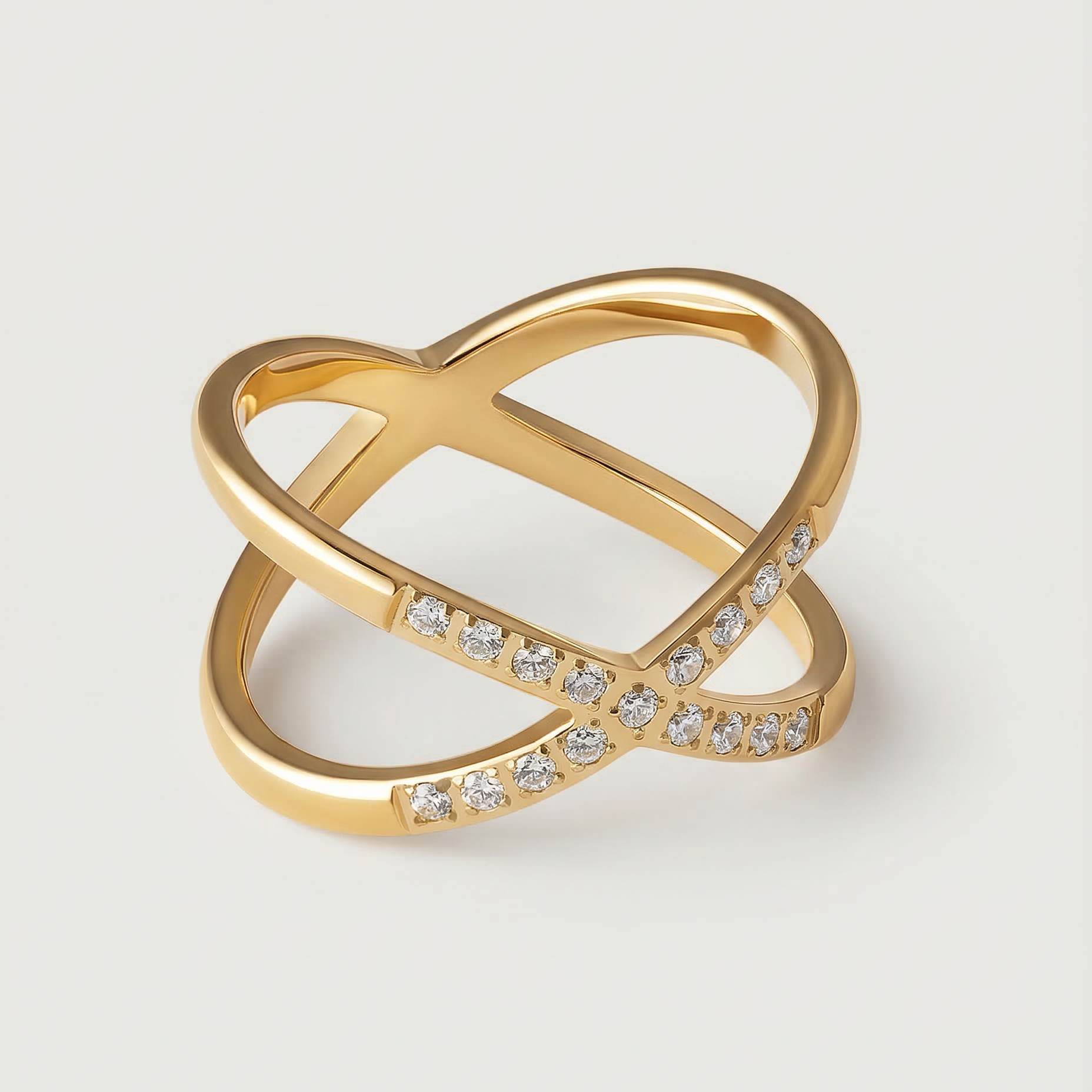 A gold ring with two intersecting bands and small stones set along one band.