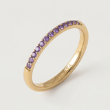 A gold-plated ring with a line of purple stones set along its circumference.