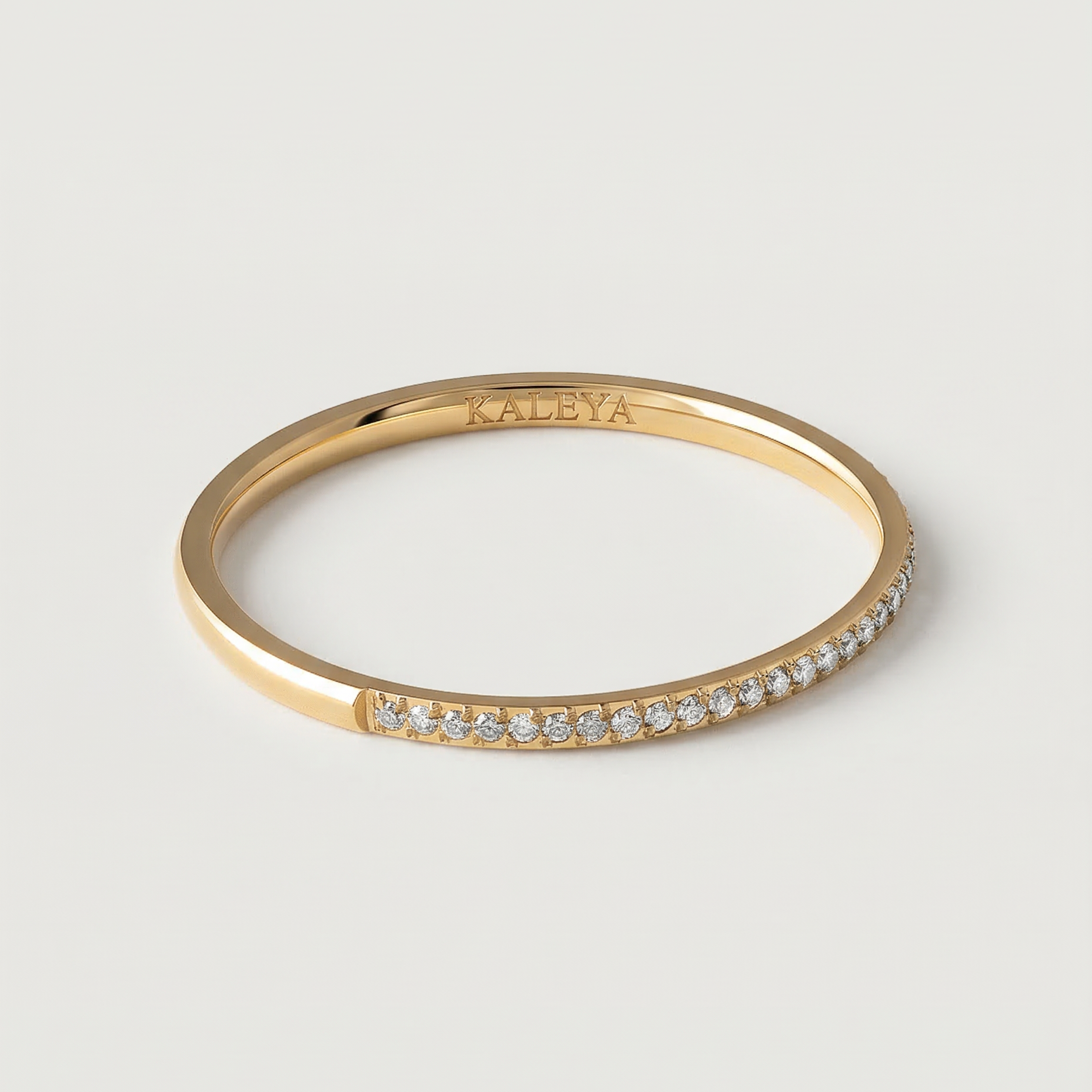 A gold-plated ring with a row of sparkling cubic zirconia stones set in a pavé effect along the band.