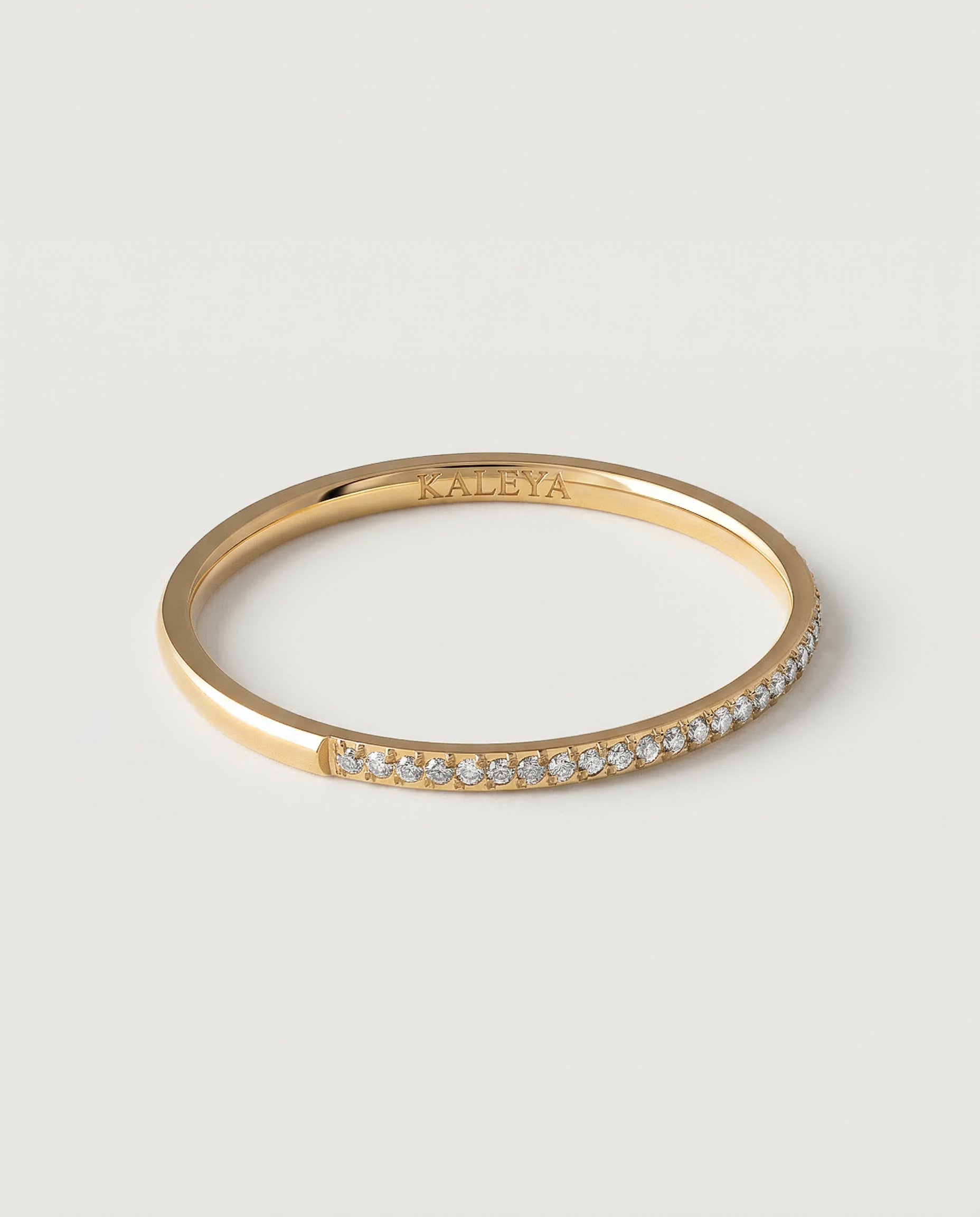 A gold-plated ring with a row of sparkling cubic zirconia stones set in a pavé effect along the band.