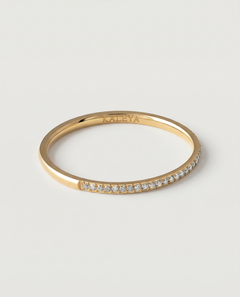 A gold-plated ring with a row of sparkling cubic zirconia stones set in a pavé effect along the band.
