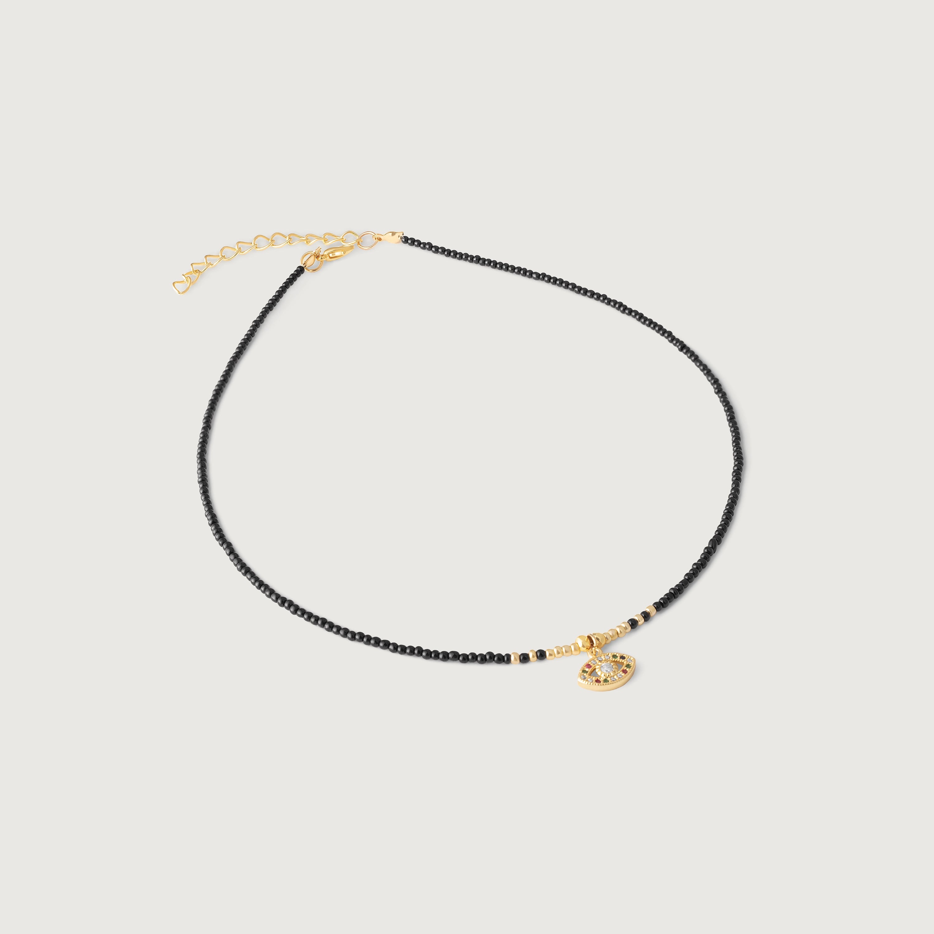 A gold-plated choker necklace with black beads and a crystal-embellished evil eye pendant, featuring an adjustable gold chain.