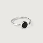 A silver ring with a twisted band and a central black onyx stone, with a small silver bead on one end.