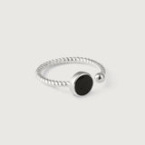 A silver ring with a twisted band and a central black onyx stone, with a small silver bead on one end.
