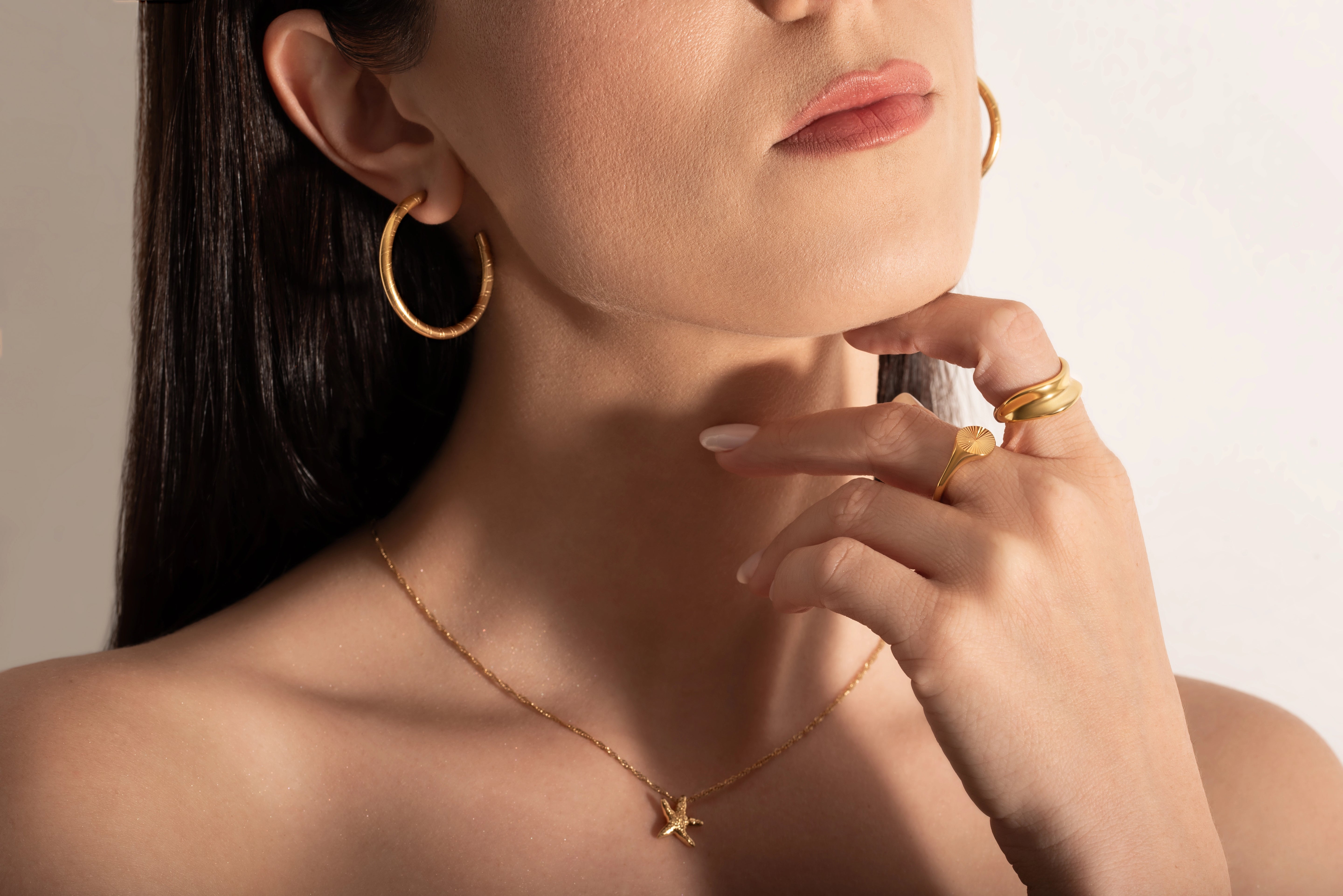 model wearing gold plated rings and necklace