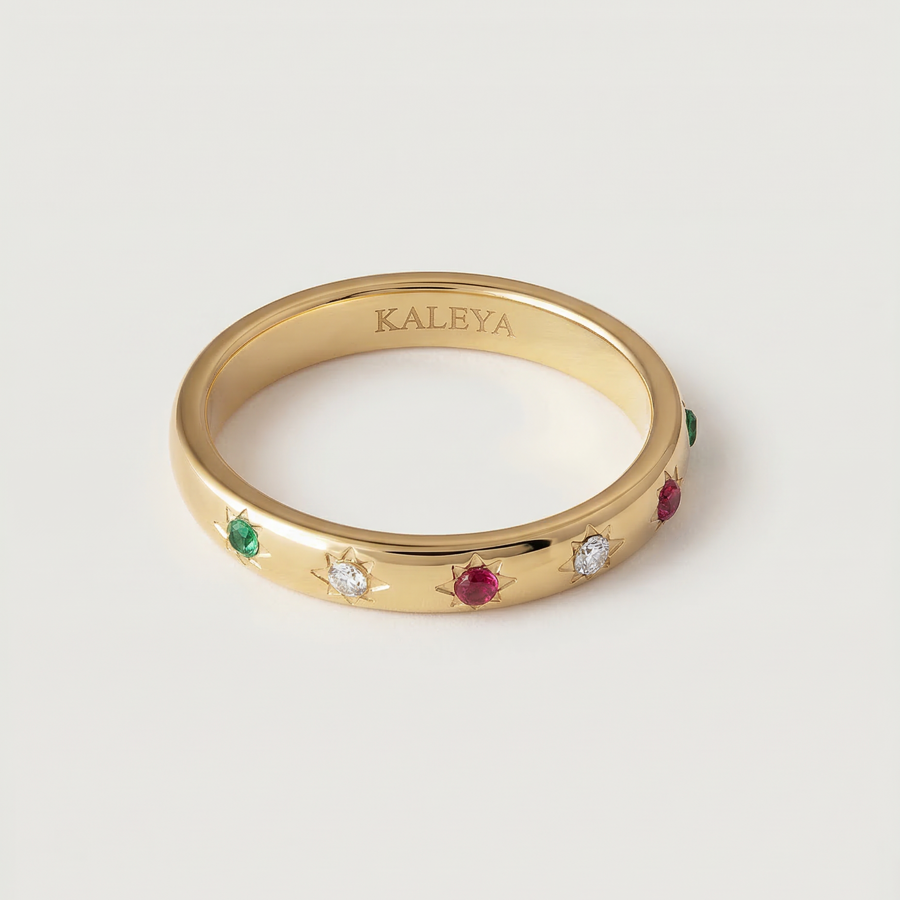 A gold-plated ring with a series of vibrant gemstones set in star-shaped bezels along the polished band.