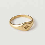 A gold signet ring with a star engraving on the top, crafted from gold-plated metal.