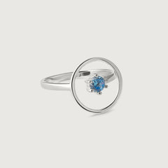 A sleek sterling silver ring with a single blue gemstone in the center, set within a circular frame.