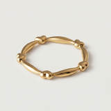 A gold-plated ring with heart-shaped links and elongated bars creating a chain-like design.
