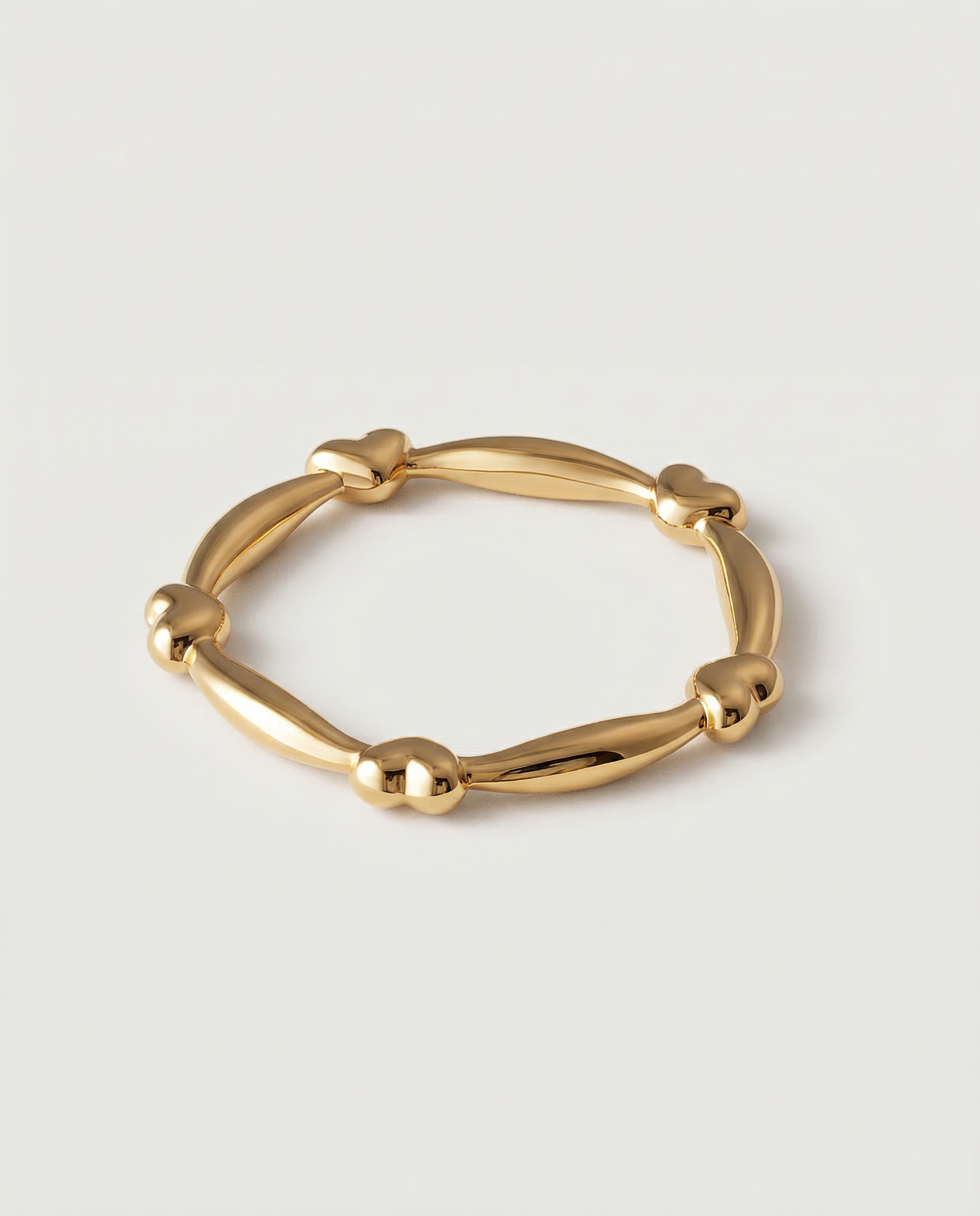 A gold-plated ring with heart-shaped links and elongated bars creating a chain-like design.