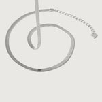 A sleek sterling silver herringbone chain necklace with an adjustable length and a heart charm, displayed against a white background.