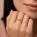 model wearing a gold-plated metal ring with a twisted rope design, displayed against a white background.