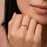 model wearing a gold-plated metal ring with a twisted rope design, displayed against a white background.