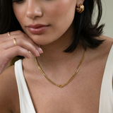 close up photo of a female model wearing a gold-plated choker necklace with a simple infinity symbol design