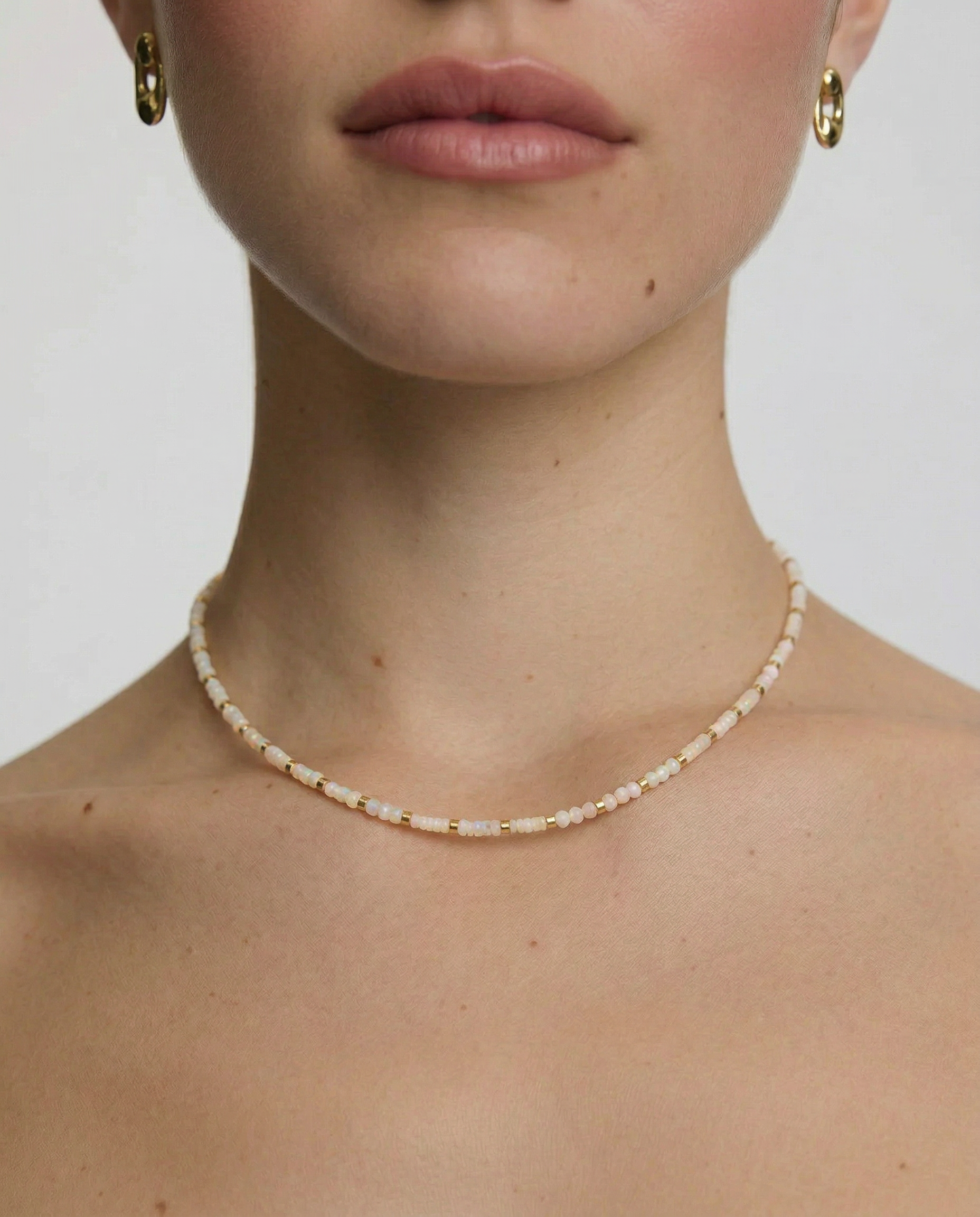 Close-up of a person wearing a delicate white beaded choker