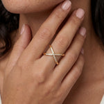 Close-up of a hand wearing a diamond ring with a neutral background