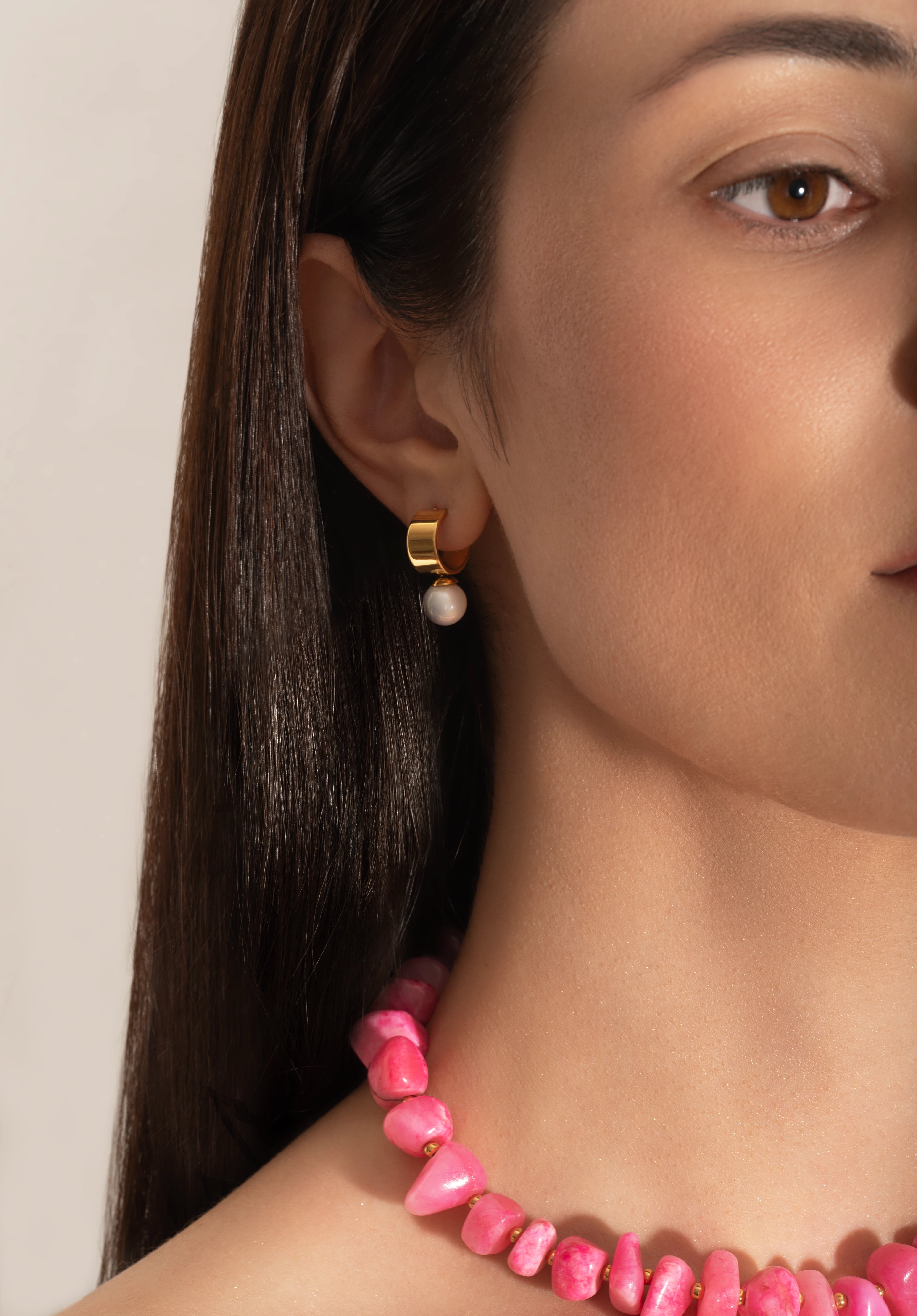 model wearing a pink coral nuggets necklace with metallic beads and a gold heart charm