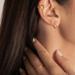 close up of  a model wearing gold plated ring and earrings