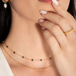 model wearing a two-tiered necklace with fine gold chains and forest-hued jasper beads,