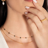 model wearing a two-tiered necklace with fine gold chains and forest-hued jasper beads,
