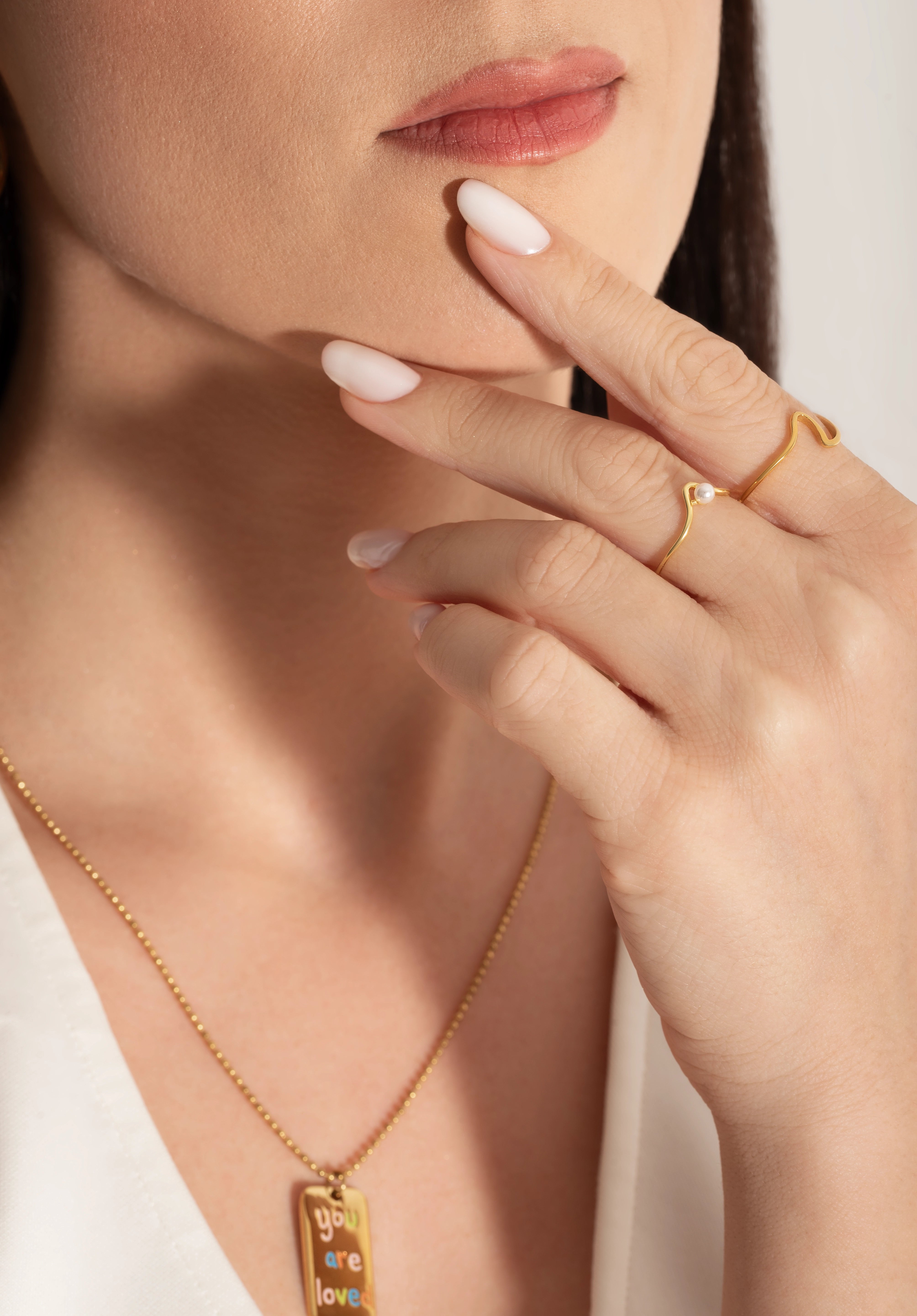 young female model wearing gold plated ring with a natural freshwater pearl