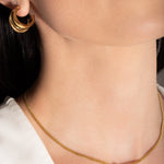 model wearing a gold-plated choker necklace with a simple infinity symbol design