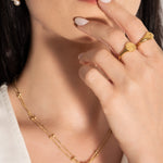model wearing two gold signet rings