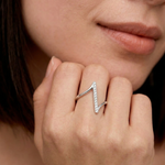 Close-up of a woman's hand wearing a sterling silver ring with a lightning bolt design adorned with cubic zirconia stones