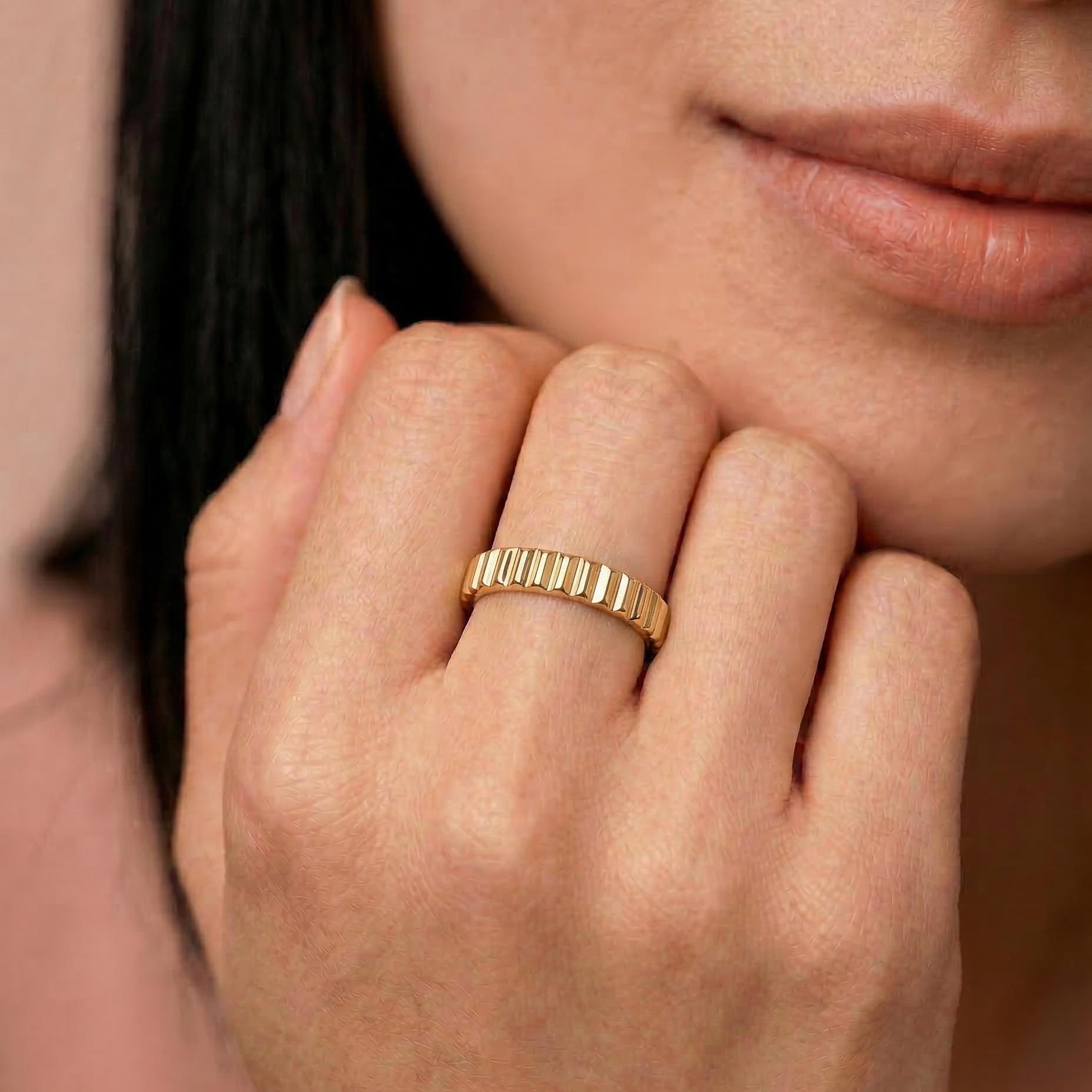 close up of a female model wearing a gold-plated band ring with fluted edges