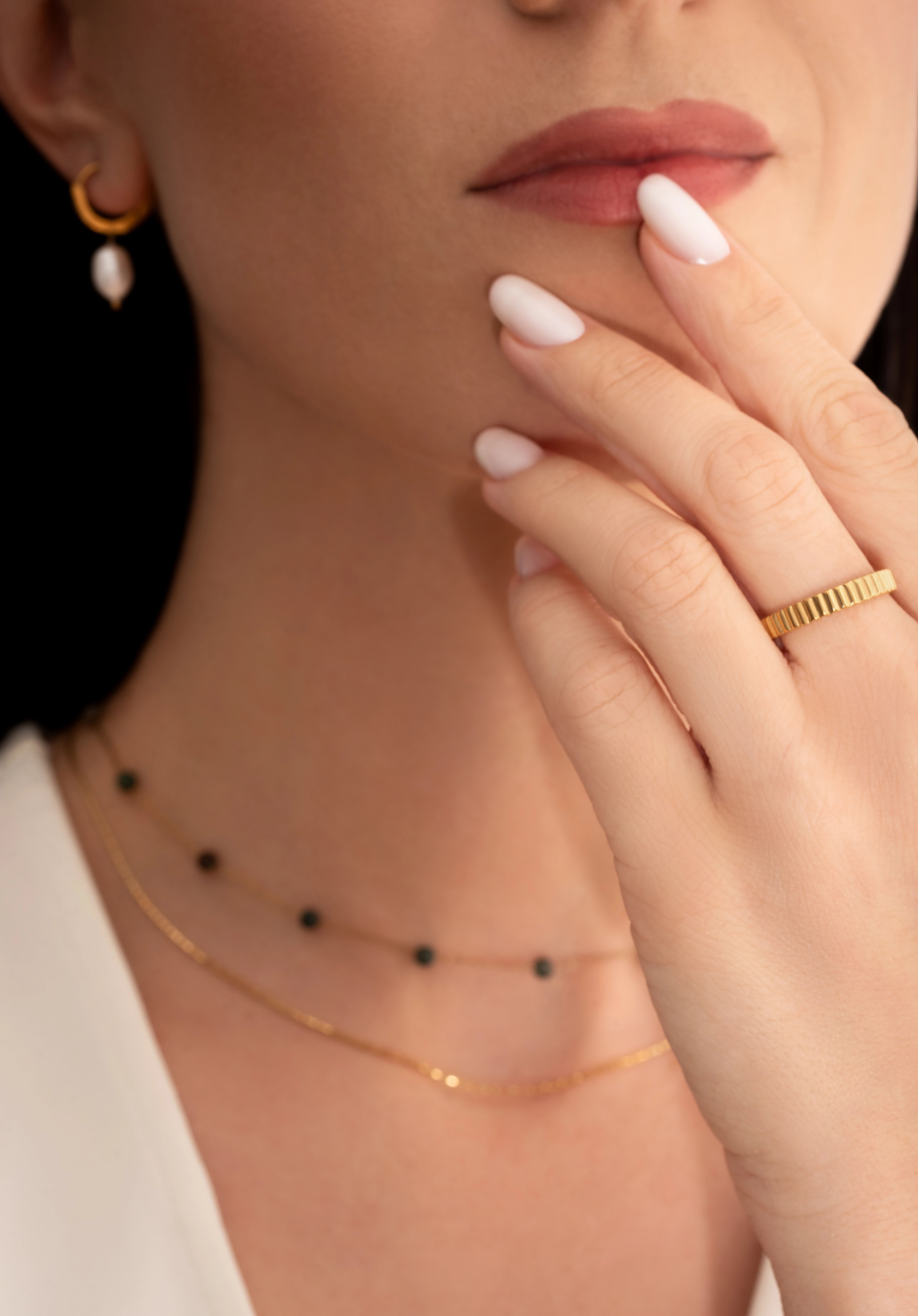 model wearing a gold-plated band ring with fluted edges