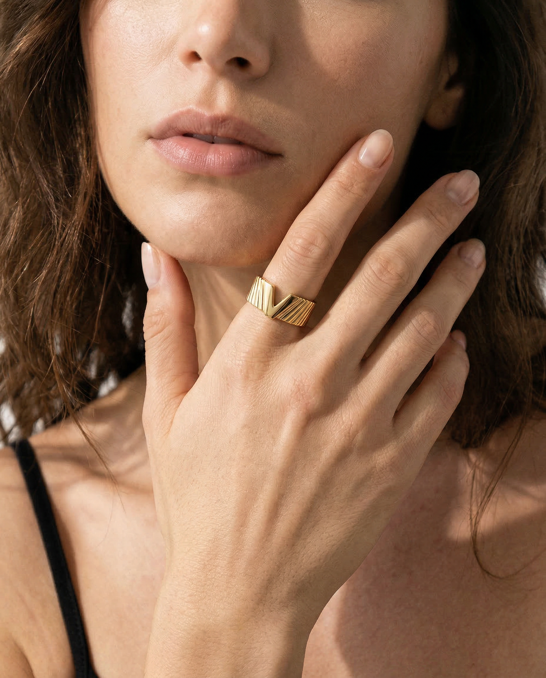 close up of a model wearing v shape gold plated ring