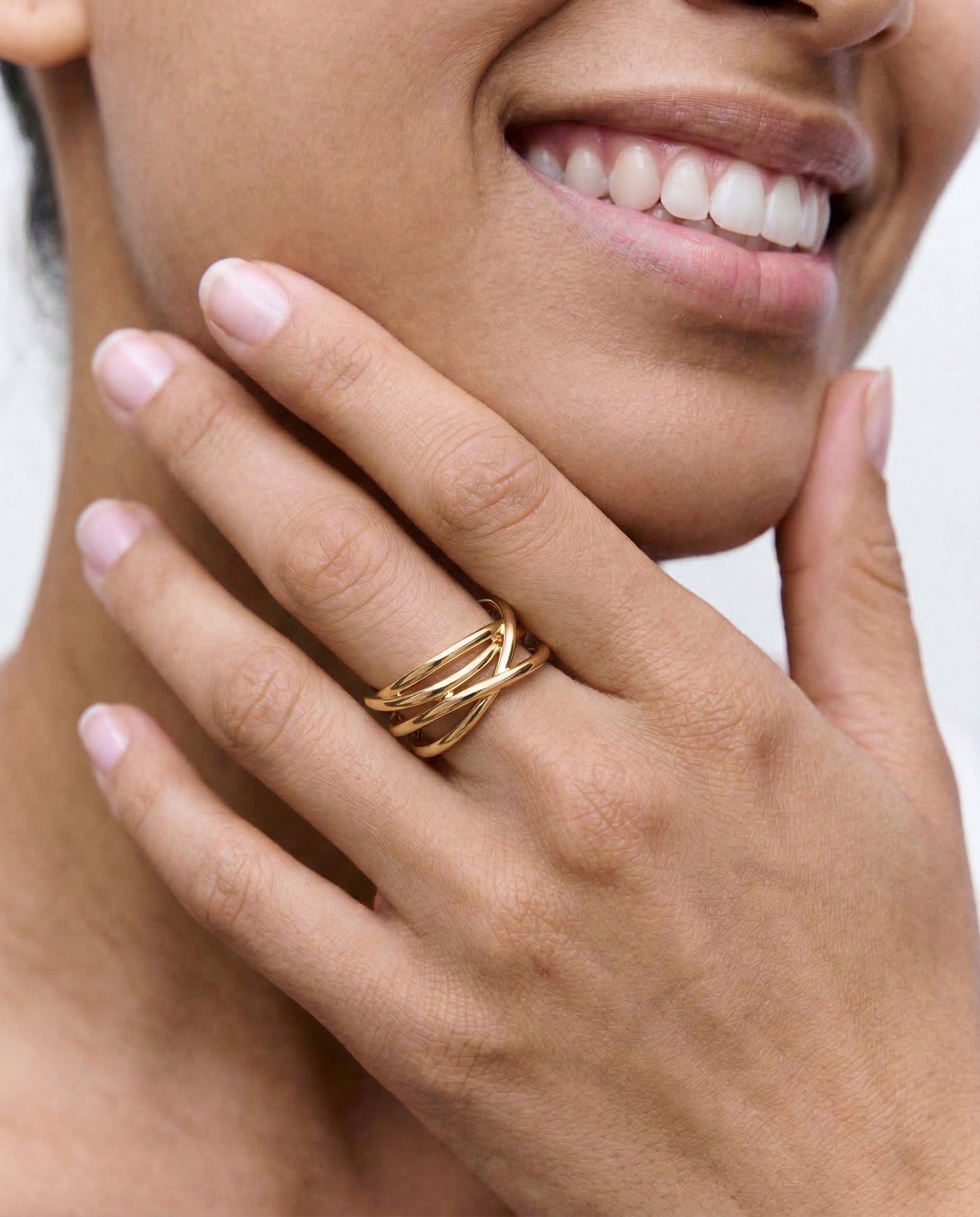 Close-up of a hand wearing a gold ring with a blurred background