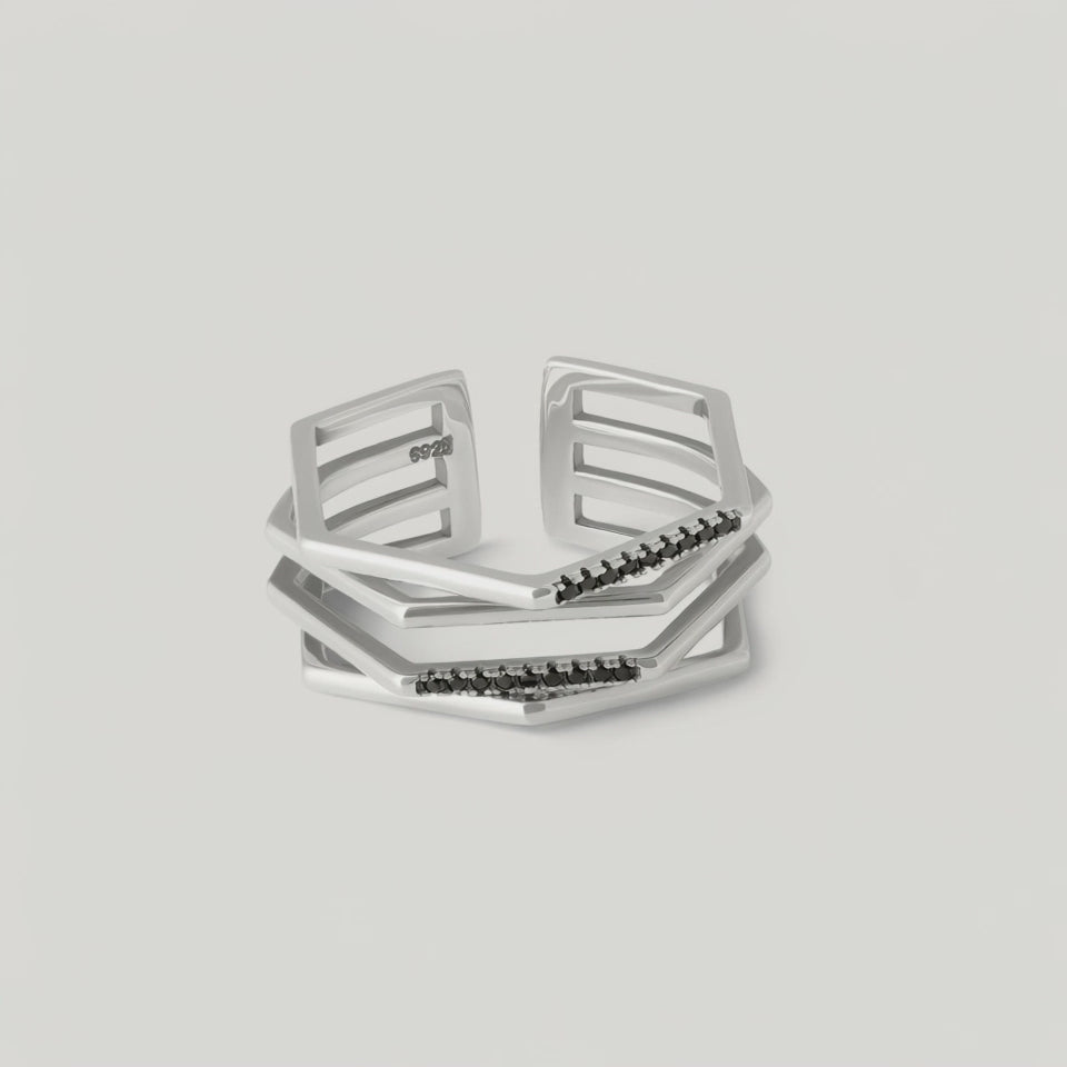 rotating video of a silver ring with a hexagonal design featuring geometric flowing lines and black crystal accents on the edges