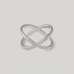video showing a silver-colored ring with an X-shaped design and sparkling cubic zirconia stones on the intersections.