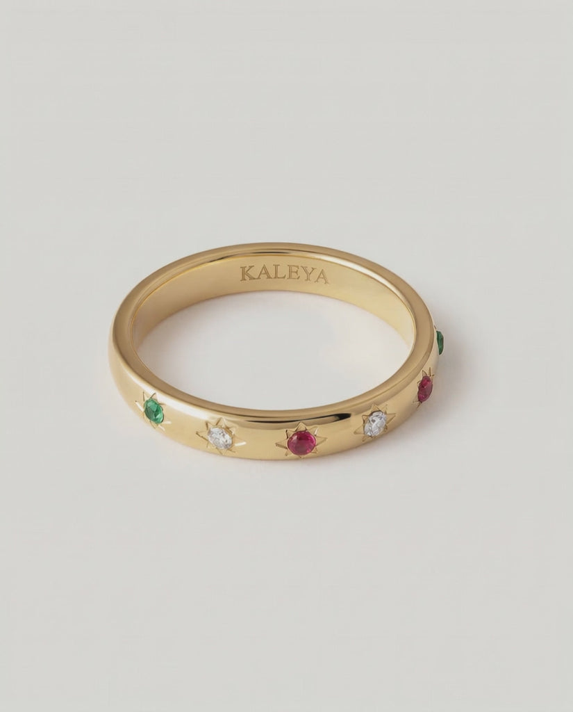 rotating video of a gold-plated ring with a series of vibrant gemstones set in star-shaped bezels along the polished band