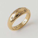 video showing a gold-plated ring with a smooth, domed surface adorned with five star-shaped bezels containing crystals
