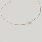 video of a single white pearl pendant on a thin gold chain