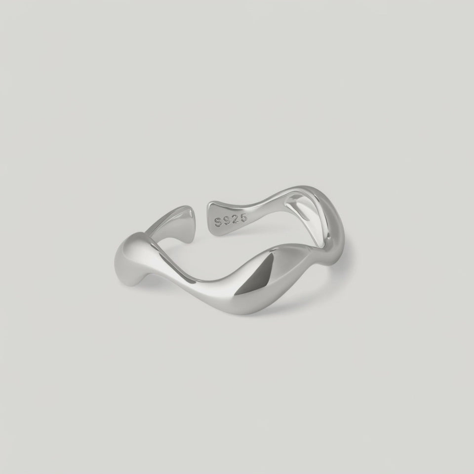 rotating video of a sleek silver ring with an undulating design, crafted from sterling silver