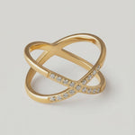 rotating video of a gold ring with two intersecting bands and small stones set along one band