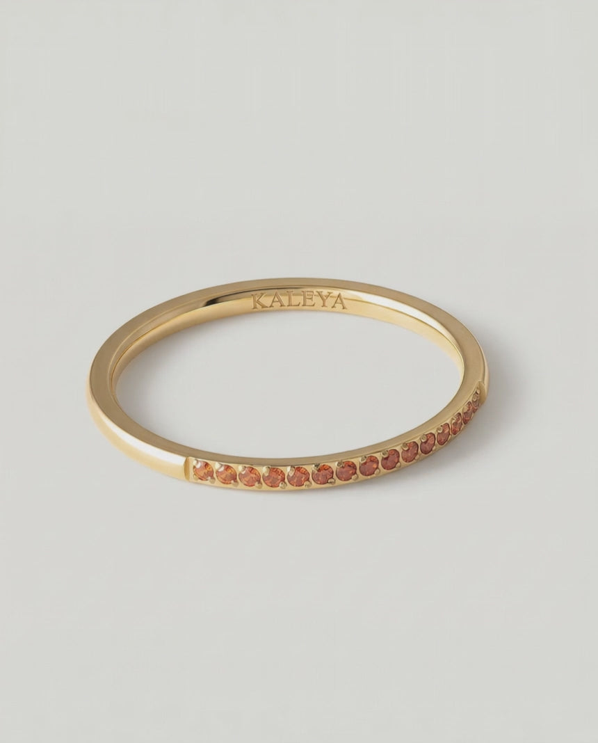 360 video of a gold-plated ring with a single row of orange crystals around its circumference.