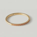 360 video of a gold-plated ring with a single row of orange crystals around its circumference.